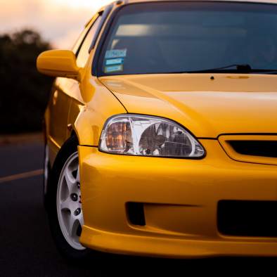 Żółte auto sportowe stoi na drodze, w tle zachód słońca - ergonomia w aucie Power Safety
