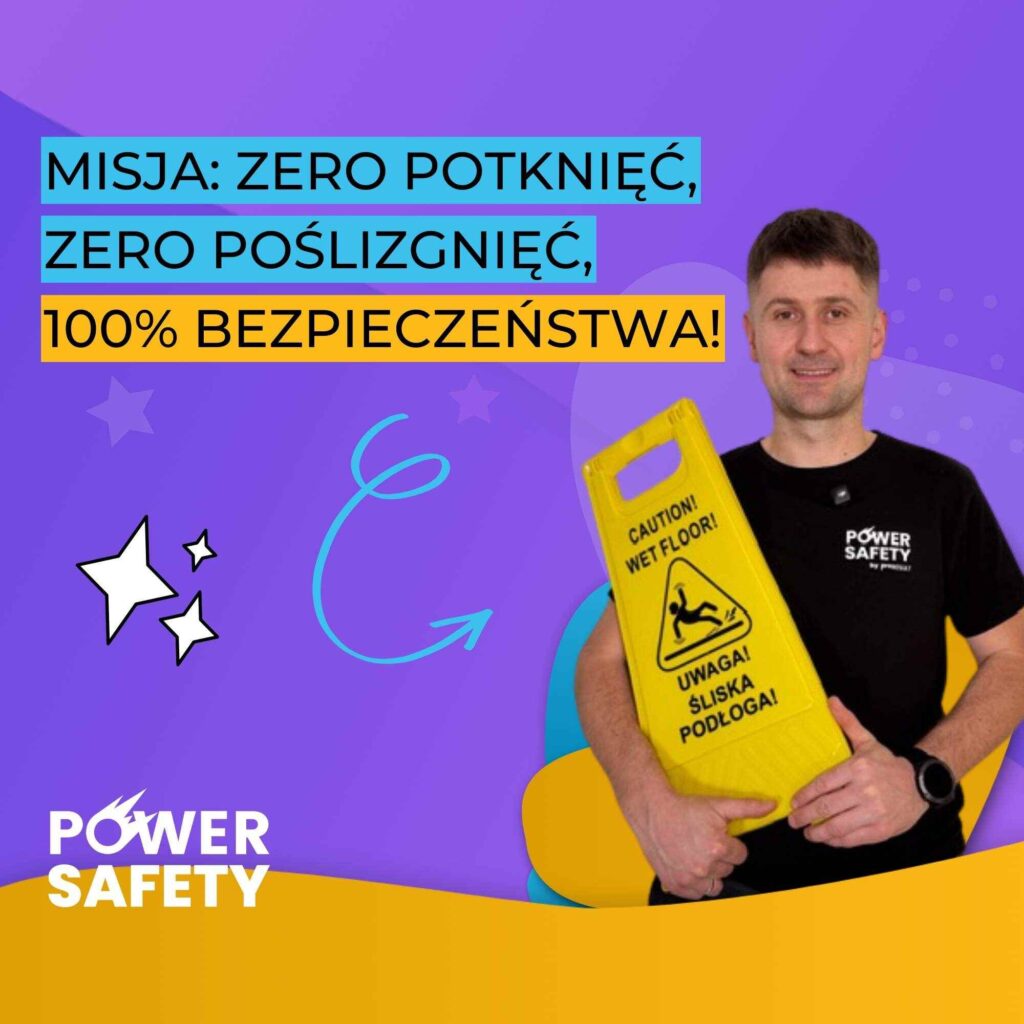 Mężczyzna w czarnej koszulce trzyma żółty piktogram informujący o śliskiej posadzce - Power Safety grywalizacja bhp online